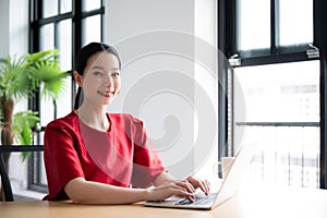 Beautiful asian woman working on a laptop at work