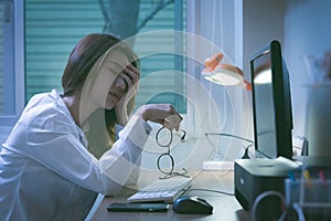 Beautiful asian woman working overtime on a computer at the night at home