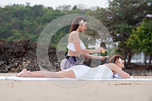 Beautiful asian woman enjoying spa massage therapy on the beach
