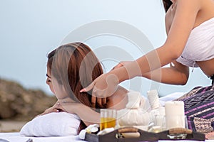 Beautiful asian woman enjoying spa massage therapy on the beach