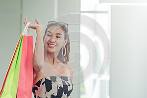 Beautiful asian women holding a shopping bags looking for the thing she just bought. Women smiling after shopping