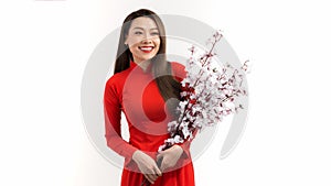 Beautiful Asian women in red traditional Vietnamese dress with holding peach blossom branch on a white background