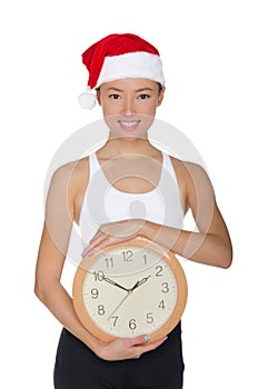 Beautiful asian women in a Santa`s hat with a clock