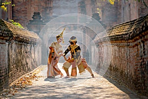 Beautiful Asian woman wear Thai traditional dress action of dancing together with Thai classic masked from the Ramakien character photo