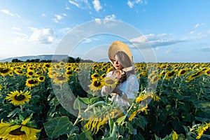A beautiful asian women in a white dress and hat walking on a field of sunflowers , smiling a beautiful smile,cheerful girl,style