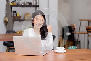 Beautiful asian young businesswoman excited and glad of success with laptop.