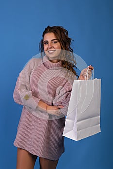 Beautiful asian young irl holding a white blank paper bag and makes purchases in an online store against a black wall background