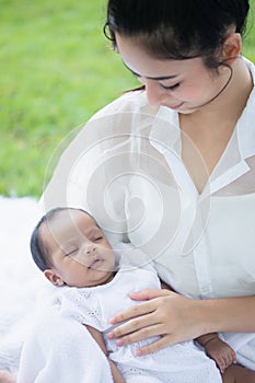 Beautiful Asian young mother  or single mom with new born baby girl are doing activities and relaxing in the park. concept of