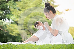 Beautiful Asian young mother  or single mom with new born baby girl are doing activities and relaxing in the park. concept of