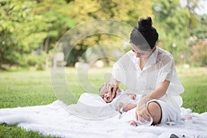Beautiful Asian young mother  or single mom with new born baby girl are doing activities and relaxing in the park. concept of