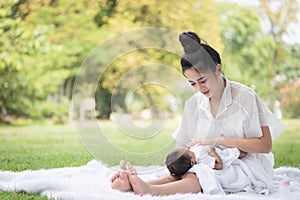 Beautiful Asian young mother  or single mom with new born baby girl are doing activities and relaxing in the park. concept of