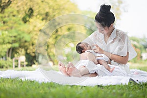 Beautiful Asian young mother  or single mom with new born baby girl are doing activities and relaxing in the park. concept of