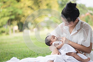 Beautiful Asian young mother  or single mom with new born baby girl are doing activities and relaxing in the park. concept of