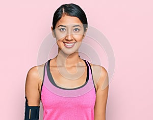 Beautiful asian young sport woman wearing sportswear and arm band with a happy and cool smile on face