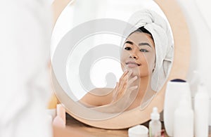 Beautiful asian young woman applying face cream