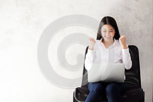 Beautiful asian young woman excited and glad of success with laptop.