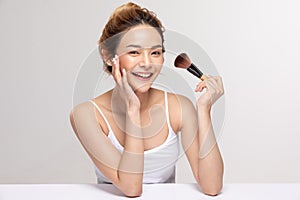 Beautiful Asian young woman smile and holding make up brush with healthy Clean and Fresh skin feeling so happiness