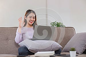 beautiful asian young woman wear casual sit on couch using computer laptop entertain with social media relax smile and