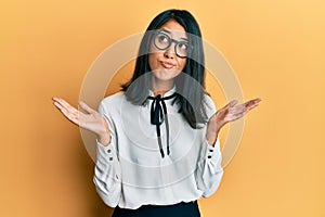 Beautiful asian young woman wearing business shirt clueless and confused with open arms, no idea and doubtful face