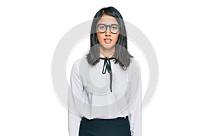 Beautiful asian young woman wearing business shirt and glasses with serious expression on face