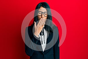 Beautiful asian young woman wearing business suit bored yawning tired covering mouth with hand