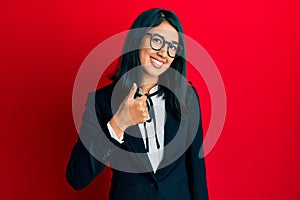 Beautiful asian young woman wearing business suit doing happy thumbs up gesture with hand