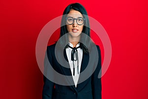 Beautiful asian young woman wearing business suit relaxed with serious expression on face