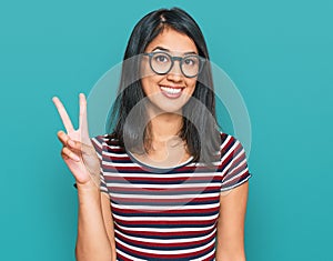Beautiful asian young woman wearing casual clothes and glasses showing and pointing up with fingers number two while smiling