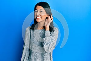 Beautiful asian young woman wearing casual clothes smiling with hand over ear listening and hearing to rumor or gossip