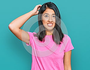 Beautiful asian young woman wearing casual pink t shirt confuse and wonder about question