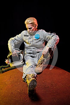 beautiful astronaut in spacesuit with helmet sitting