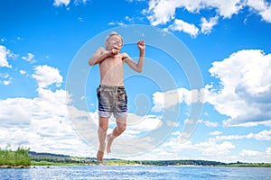 Beautiful athletic boy high jumps on the beach