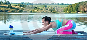 Beautiful athletic girl doing yoga against the backdrop of beautiful nature, pose asana Balasana. The concept of a healthy