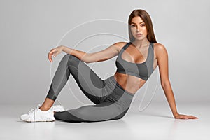 Beautiful athletic girl, fitness woman on gray background