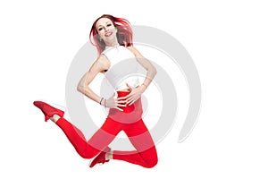 A beautiful, athletic, slender, smiling and cheerful woman in a white top and red sweatpants performs pragues. Dance