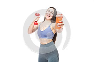 A beautiful, athletic, slim, smiling and cheerful woman holds a red dumbbell and a shaker with water. Lifestyle concept