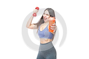 A beautiful, athletic, slim, smiling and cheerful woman holds a red dumbbell and a shaker with water. Lifestyle concept