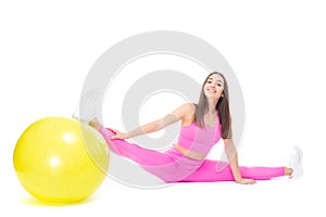 A beautiful, athletic, slim, smiling and cheerful woman in a pink tracksuit demonstrates stretching. Sits on a twine