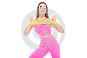 A beautiful, athletic, slim, smiling and cheerful woman in a pink tracksuit performs an exercise on the muscles of the