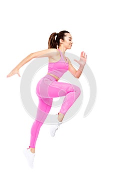 A beautiful, athletic, slim, smiling and cheerful woman in a pink tracksuit performs jumps up and forward. Lifestyle