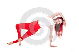 A beautiful, athletic, slim, smiling and cheerful woman in a white top and red sweatpants performs stretching and