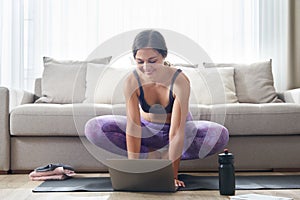 Beautiful Athletic Sporty Woman Sitting On Yoga Mat After Some Exercises Drinks Protein Shake or water