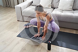 Beautiful Athletic Sporty Woman Sitting On Yoga Mat After Some Exercises Drinks Protein Shake or water