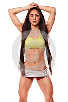 Beautiful athletic woman with long hair posing. Fitness girl showing muscular athletic body, abs. Isolated