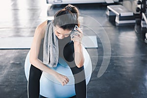 Beautiful Athletic Woman is Wiping Sweat With Towel After Exercised in Gym, Portrait of Pretty girl in Sportswear is Exercising in