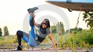 Beautiful, athletic, young woman in sunglasses, in tights, performs different strength exercises, jumps, push-ups