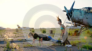 Beautiful, athletic, young women in sunglasses, in tights, perform synchronously different strength exercises, jumps