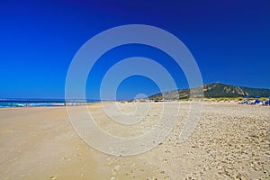 Beautiful atlantic ocean empty natural sand beach, hills, clear cloudless blue sky - Zahara de los Atunes, Costa de la Luz, Spain photo