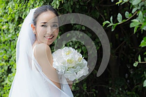 Beautiful Attractive Asian Bride Woman wearing white wedding dress and holding bouquet smile