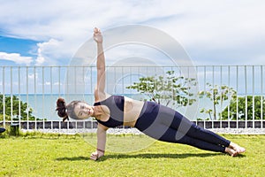 Beautiful Attractive Asian woman practice yoga side plank pose stretching exercises muscle